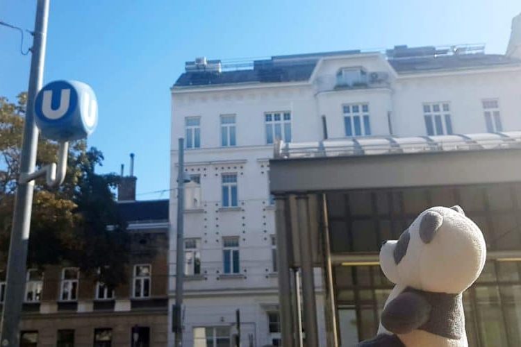 Plush toy Mister Wong looking at the U sign which indicated that there is a Vienna subway station near him.